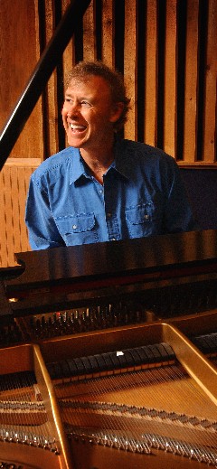 Bruce Hornsby at the piano, talking with Jim Newsom; photo by Kathy Keeney